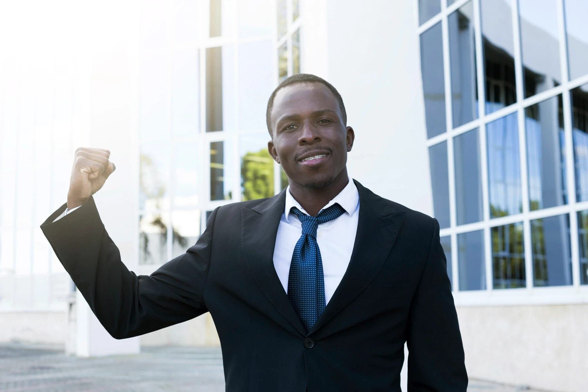 Confident investor celebrating outside a modern building
