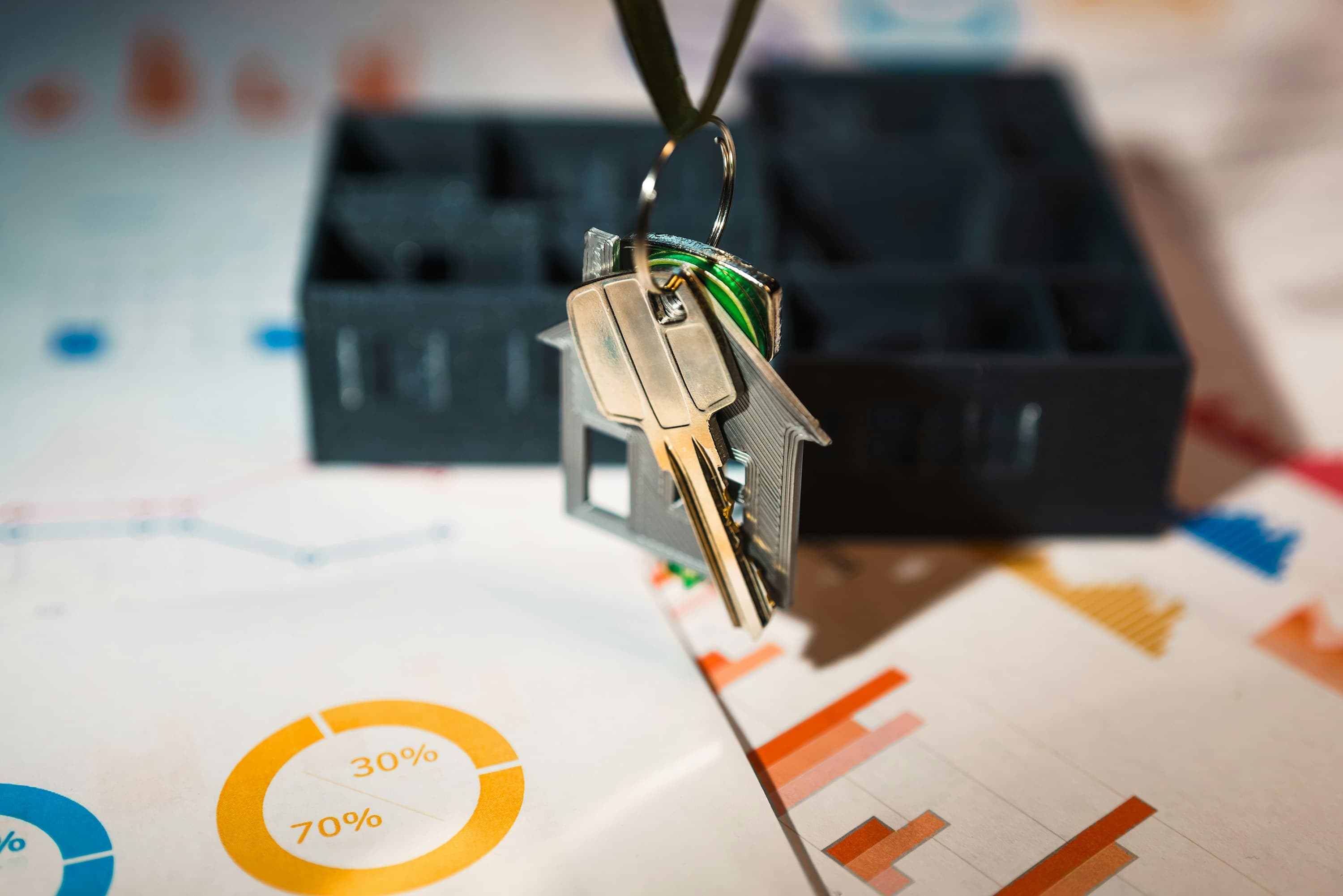 House keys resting above property performance charts